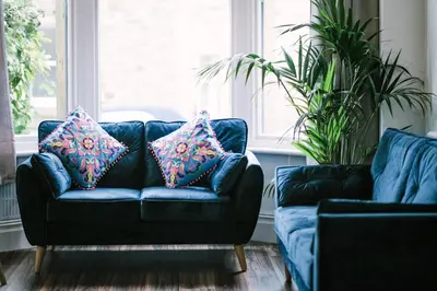 a blue couch with two pillows on it in a living room at Period Retreat for 6, explore the Lake District in Lancaster