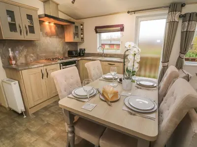 a kitchen and dining room with a table and chairs at Lancaster Lodge in Carnforth