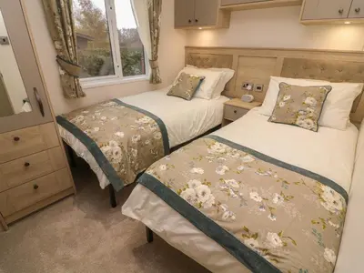 two beds in a small room with a window at Lancaster Lodge in Carnforth