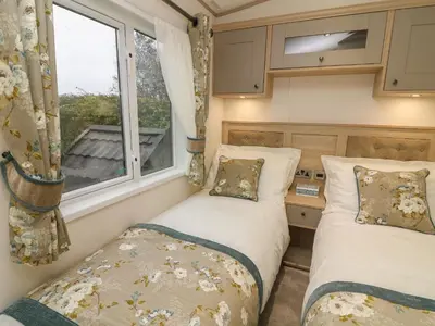 two beds in a small room with a window at Lancaster Lodge in Carnforth