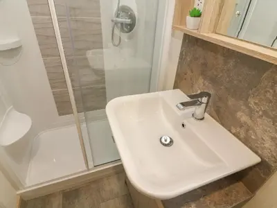 a bathroom with a white sink and a shower at Lancaster Lodge in Carnforth