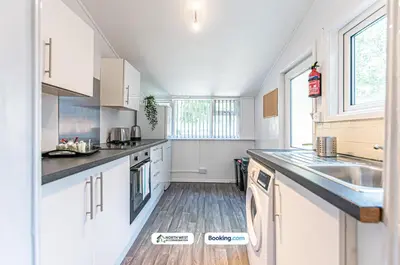 a kitchen with white cabinets and a sink at Spacious 3 BR House in PR6 Free Parking & WiFi Sleeps 6 in Chorley