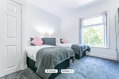 a bedroom with two beds and a window at Spacious 3 BR House in PR6 Free Parking & WiFi Sleeps 6 in Chorley