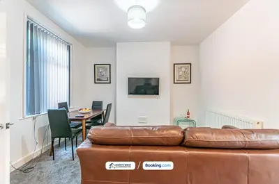 a living room with a leather couch and a table at Spacious 3 BR House in PR6 Free Parking & WiFi Sleeps 6 in Chorley