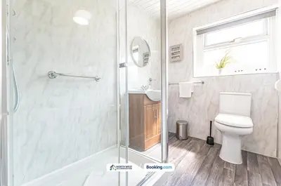 a bathroom with a shower and a toilet and a sink at Spacious 3 BR House in PR6 Free Parking & WiFi Sleeps 6 in Chorley