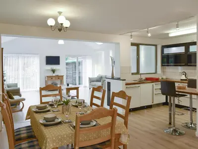 a kitchen and living room with a table and chairs at Belmont in Longton
