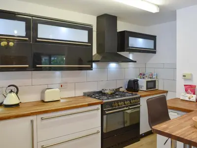 a kitchen with a stove top oven next to a table at Belmont in Longton