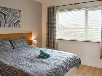 a bedroom with a bed with a blue stuffed animal on it at Belmont in Longton