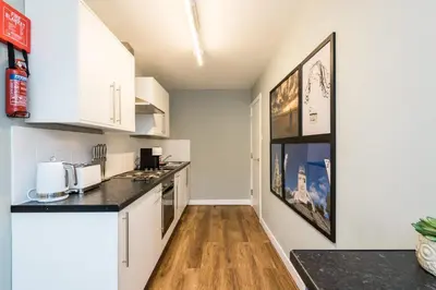 a kitchen with white cabinets and black counter tops at Host & Stay - Canning Quarters in Liverpool
