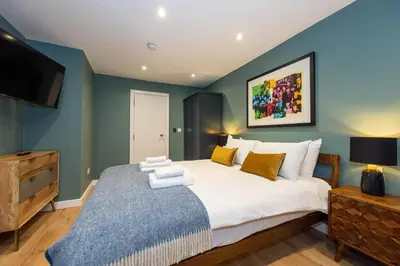 a bedroom with a large bed and a flat screen tv at Host & Stay - Canning Quarters in Liverpool