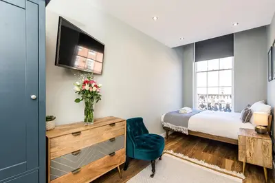 a bedroom with a bed and a dresser with a television at Host & Stay - Canning Quarters in Liverpool