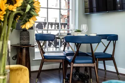 a table with blue chairs in a room with a window at Host & Stay - Canning Quarters in Liverpool