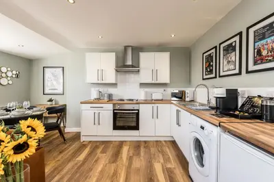 a kitchen with white cabinets and a dining room at Host & Stay - Catharine Quarters in Liverpool