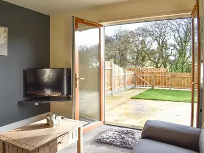 a living room with a tv and a sliding glass door at One Dorchester Drive - Uk32037 in Inglewhite