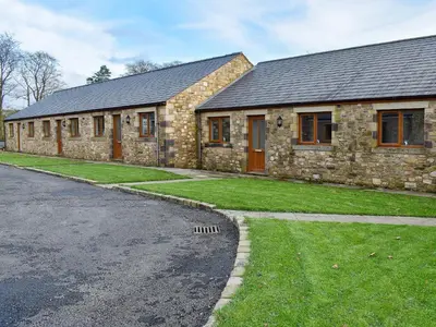 a stone house with a grass yard next to a street at One Dorchester Drive - Uk32037 in Inglewhite