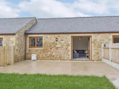 a stone house with a patio in front of it at Three Dorchester Drive - Uk32039 in Inglewhite
