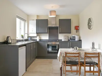 a kitchen with a table and a kitchen with gray cabinets at Three Dorchester Drive - Uk32039 in Inglewhite