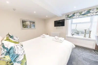 a bedroom with a white bed and a window at The Pheasant Inn in Grange Over Sands