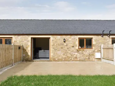 a stone house with a wooden fence in front of it at Two Dorchester Drive - Uk32036 in Inglewhite