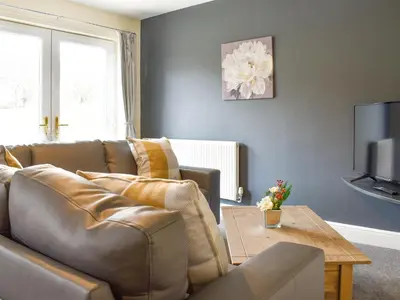 a living room with a leather couch and a table at Two Dorchester Drive - Uk32036 in Inglewhite