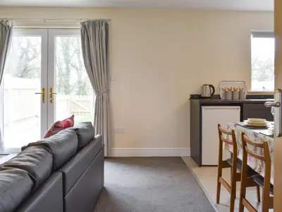 a living room with a couch and a kitchen at Four Dorchester Drive - Uk32042 in Inglewhite