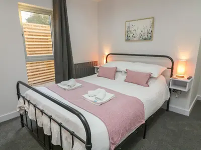 a bedroom with a bed with two towels on it at Box Tree Escapes in Lancaster