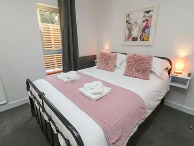 a bedroom with a large bed with two towels on it at Box Tree Escapes in Lancaster