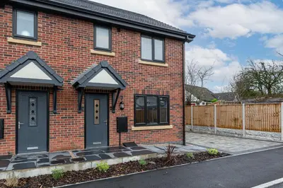 a red brick house with a black door at Tannery Place - 3 Bedrooms Parking Wi-Fi Garden in Freckleton
