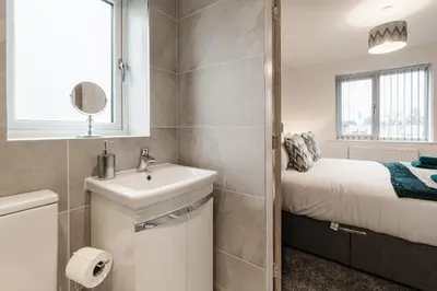a small bathroom with a sink and a bed at Tannery Place - 3 Bedrooms Parking Wi-Fi Garden in Freckleton