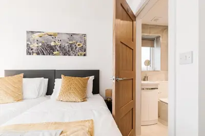 a bedroom with a bed with white sheets and yellow pillows at Tannery House - 3 Bedrooms, Parking, Wi-Fi, Garden in Freckleton