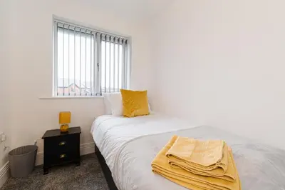 a bedroom with a bed with a yellow blanket on it at Tannery House - 3 Bedrooms, Parking, Wi-Fi, Garden in Freckleton