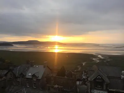 a sunset over a body of water with houses at The View in Grange Over Sands
