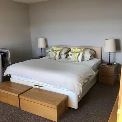a bedroom with a large white bed with two lamps at The View in Grange Over Sands