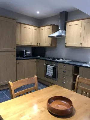 a kitchen with a wooden table with a wooden bowl on it at The View in Grange Over Sands
