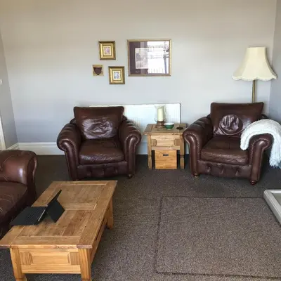 a living room with leather chairs and a coffee table at The View in Grange Over Sands