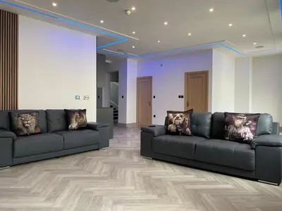 two black couches in a living room with wooden floors at Eleanor Rigby apts Stanley Street in Liverpool