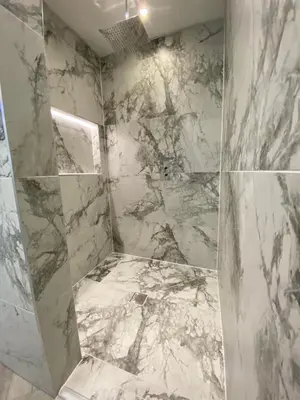 a bathroom with marble walls and a shower stall at Eleanor Rigby apts Stanley Street in Liverpool