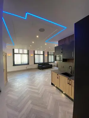 a large living room with blue lights on the ceiling at Eleanor Rigby apts Stanley Street in Liverpool