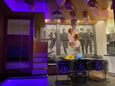 a dining room with purple lighting and a table with balloons at Eleanor Rigby apts Stanley Street in Liverpool
