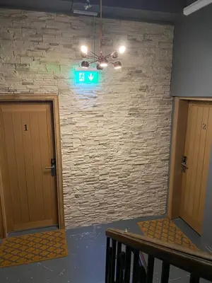 a exit sign in a room with a brick wall at Eleanor Rigby apts Stanley Street in Liverpool