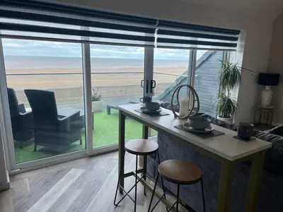 a kitchen with a table and a view of the ocean at Beach View Apartment with balcony and sea view - pet friendly in Cleveleys