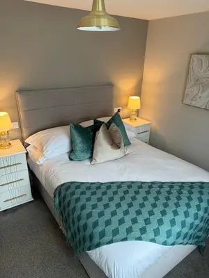 a bedroom with a large bed with two lamps at Beach View Apartment with balcony and sea view - pet friendly in Cleveleys