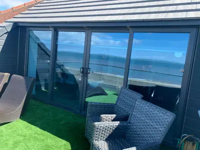 a balcony with chairs and a view of the ocean at Beach View Apartment with balcony and sea view - pet friendly in Cleveleys