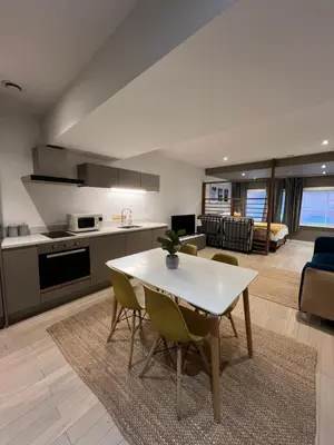 a kitchen and living room with a table and chairs at Beautiful City Centre Apartment in Liverpool