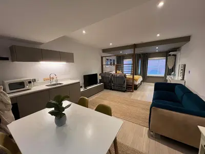 a kitchen and living room with a couch and a table at Beautiful City Centre Apartment in Liverpool