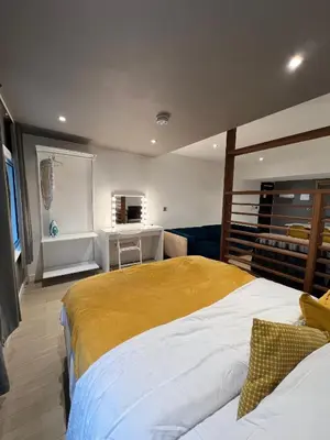 a bedroom with two beds and a desk at Beautiful City Centre Apartment in Liverpool