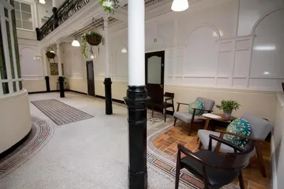 a large room with a column and chairs in it at Beautiful City Centre Apartment in Liverpool