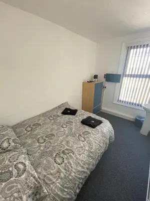 a bedroom with a bed with two black shoes on it at The Honley hotel in Blackpool