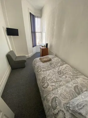 a bedroom with a bed and a chair in it at The Honley hotel in Blackpool