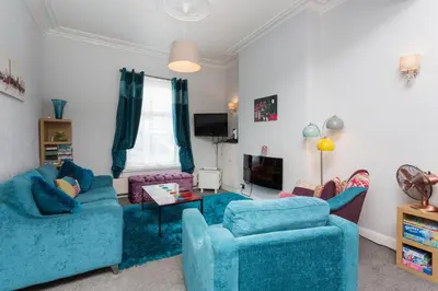 a living room with two blue couches and a tv at Langan's Blackpool Holiday Let in Blackpool